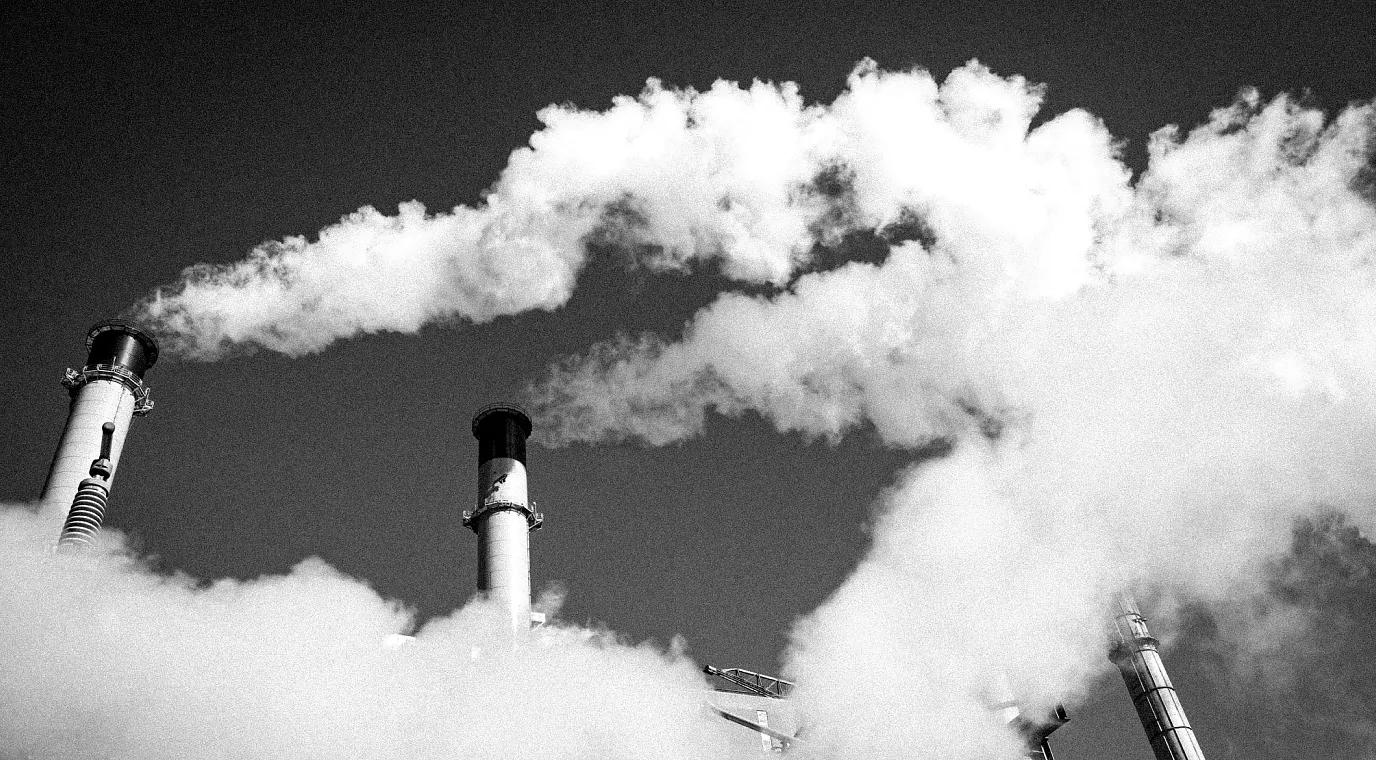 Smoke stacks billowing thick smoke into the sky.