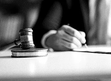 Policymaker drafting legislation at a table with a gavel.
