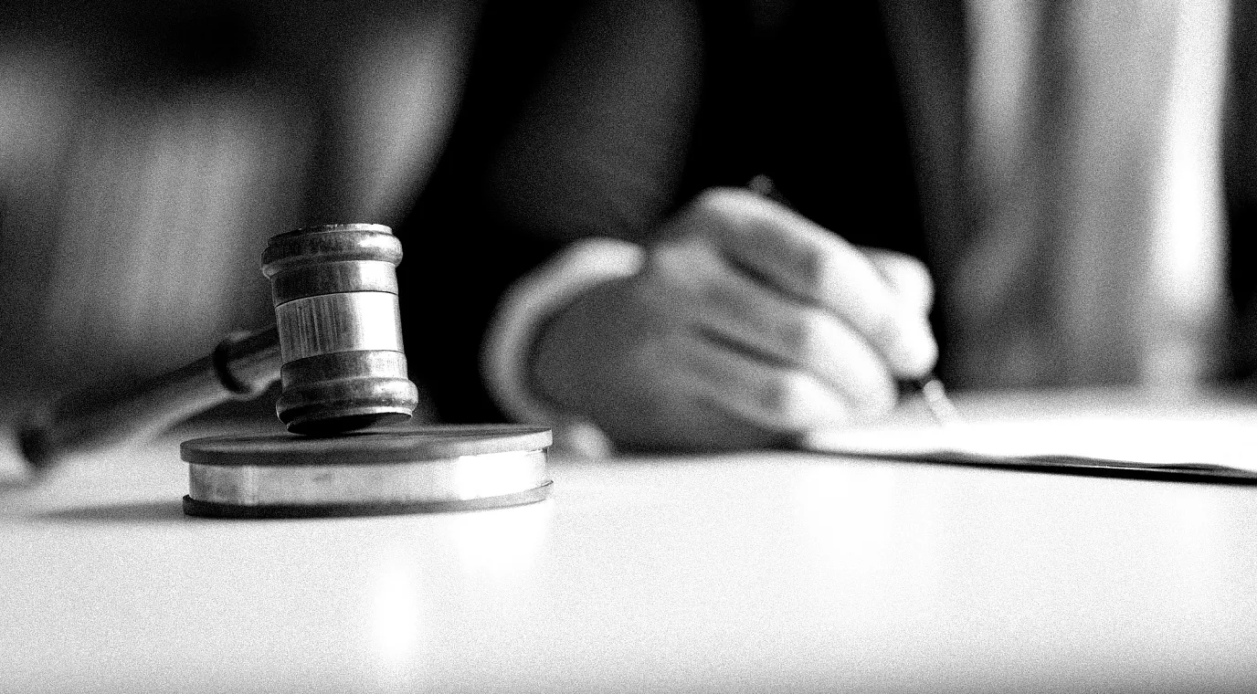 Policymaker drafting legislation at a table with a gavel.